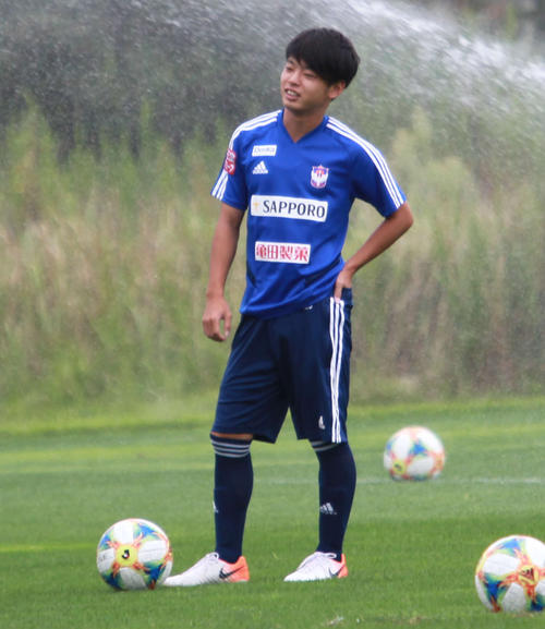 トレーニング前に水をまくピッチに立つMF本間
