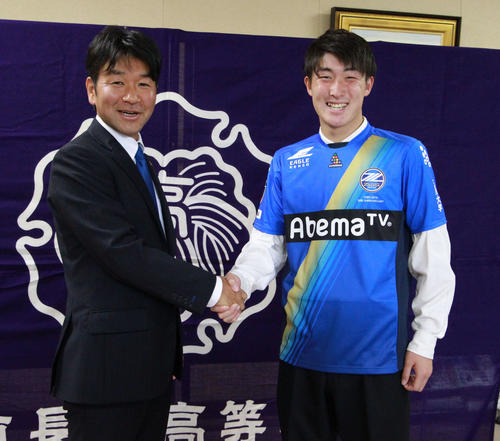 J2町田の丸山強化部長（左）と握手を交わし晴山は笑顔を見せる（撮影・涌井幹雄）