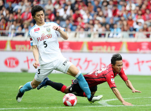 川崎F対札幌　延長前半、ペナルティーエリア付近で札幌MFチャナティップ（右）をファウルで倒す川崎F・DF谷口（撮影・垰建太）