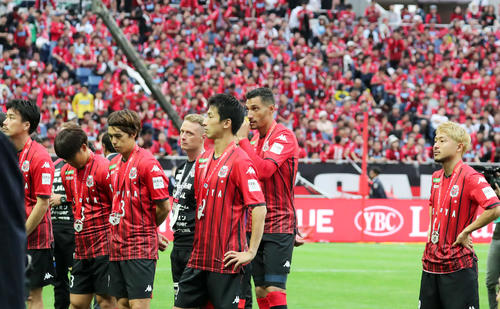 優勝を決めた川崎Fの表彰を悔しそうに見つめる札幌の選手たち（撮影・垰建太）