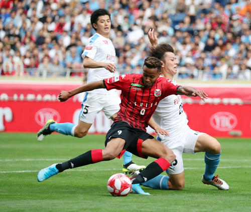 川崎F対札幌　前半、競り合いながらシュートを放つ札幌FW鈴木。右は川崎F・MF田中（撮影・垰建太）