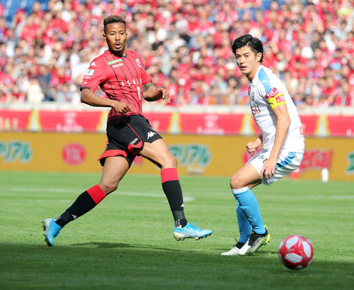 川崎F対札幌　前半、競り合う川崎F・DF谷口（右）と札幌FW鈴木（撮影・垰建太）