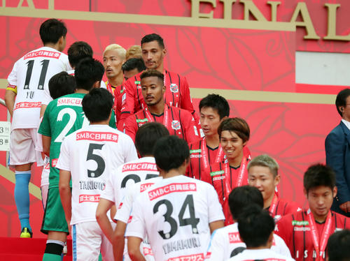 川崎F対札幌　試合後、悔しそうな表情で準優勝の表彰を受けた札幌鈴木（右上から4人目）ら選手たちは川崎Fの選手たちと握手を交わす（撮影・垰建太）