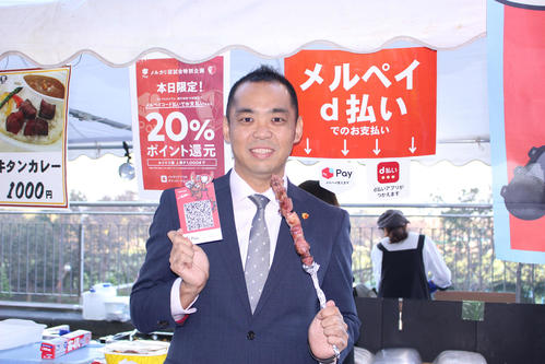 メルペイ決済でカシマスタジアム名物「五浦ハム」を購入した、鹿島アントラーズ小泉文明社長（撮影・杉山理紗）