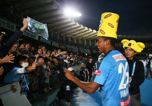 川崎F対広島　後半、決勝ゴールの川崎F・DFマギーニョ（左）はサポーターにお菓子をプレゼントする（撮影・足立雅史）