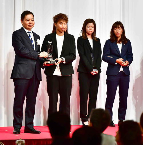 プレナスなでしこリーグ2019表彰式で最優秀選手賞を受賞した日テレ・ベレーザFW田中は日本女子サッカーリーグ岩上理事長（左）からトロフィーの贈呈を受ける。後方右へベストイレブンの長谷川、中島（撮影・小沢裕）