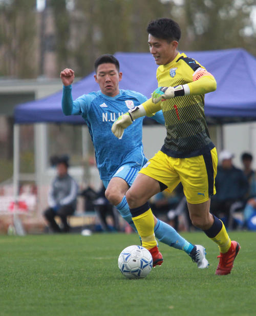 新潟医療福祉大FW矢村（左）は、相手GKを追い込みプレッシャーをかける