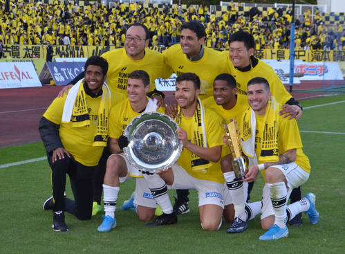 J2優勝とJ1昇格を決め、優勝杯を掲げて記念撮影する柏のクリスティアーノら（前列左から3人目）（撮影・松尾幸之介）