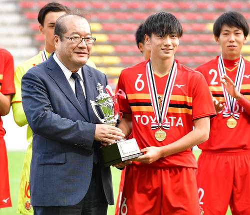 Jユース杯に優勝した名古屋。DF新玉は日刊スポーツ橘代表取締役社長（左）から朝日・日刊杯を受け取る（撮影・清水貴仁）