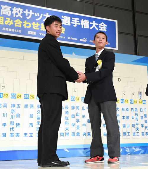 第98回全国高校サッカー選手権組み合わせ抽選会　開幕戦での対戦が決まり、握手をする国学院久我山・明田主将（左）と前原・平川主将（撮影・加藤諒）