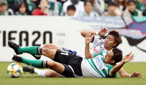 松本対横浜　後半、松本DF橋内（手前）と激しく競り合う横浜DF畠中（撮影・狩俣裕三）