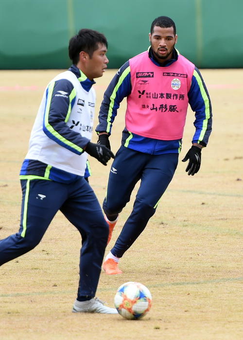 プレッシャーをかける山形FWバイアーノ（右）とDF野田
