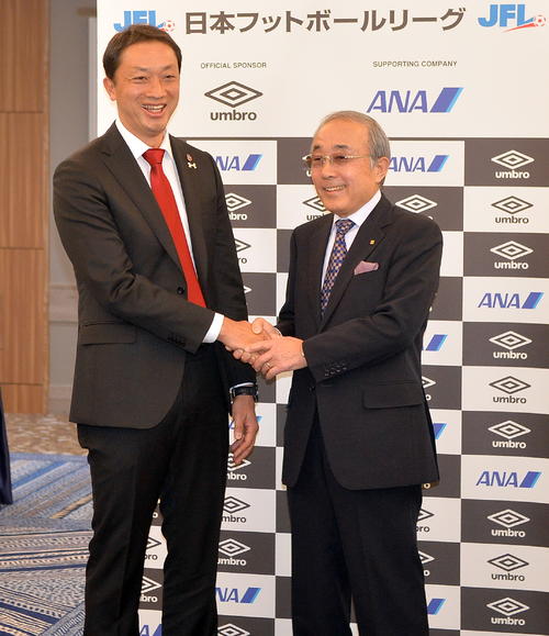 JFL桑原勝義理事長（右）から昇格の正式決定を伝えられて笑顔を見せる、いわきFC大倉社長（撮影・鎌田直秀）
