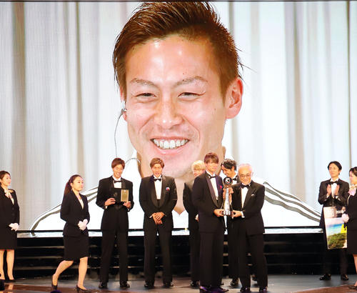 MVPに輝いた横浜FW仲川は代理でトロフィーを受け取るチームメートを見ながら笑顔を見せる（撮影・垰建太）
