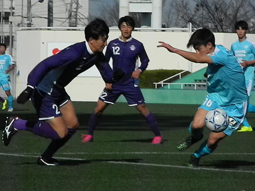 明大DF中村（左）が筑波大DF三浦をかわし、ドリブルで縦へ抜ける
