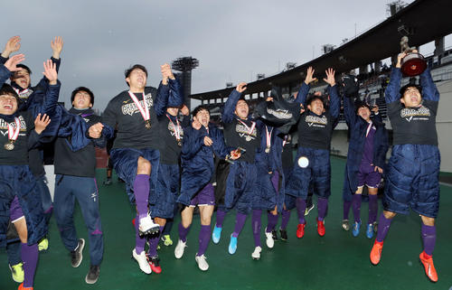 明大対桐蔭横浜大　応援席の前で優勝杯を高々と掲げ、喜び合う佐藤亮主将（右端）ら明大の選手たち（撮影・狩俣裕三）