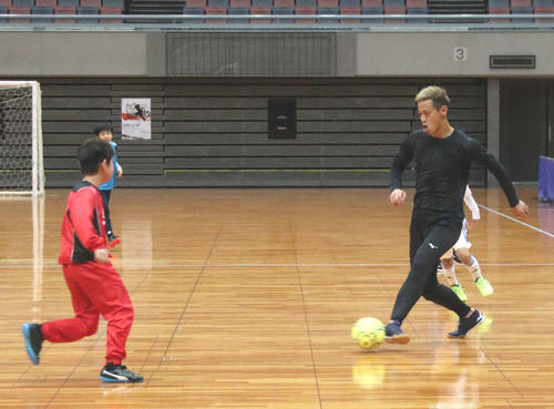 子どもたちとフットサルをする本田（撮影・南谷竜則）