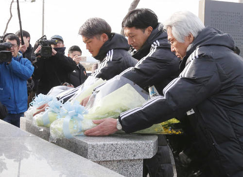 チーム始動日に、東日本大震災で被災した仙台・荒浜地区を訪れ、慰霊碑に献花する左から仙台道渕、木山監督、菊池社長ら（撮影・野上伸悟）