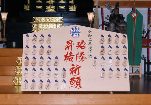 J2山形の選手、関係者たちが諏訪神社に供えられるナスをかたどる絵馬にサインを書いて、特大絵馬に飾った