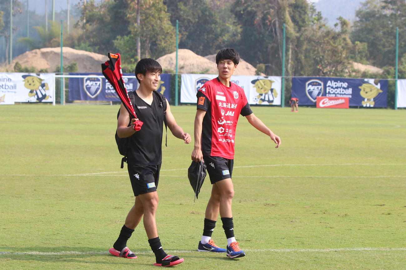 MF金子（左）とグラウンドを引き揚げる札幌DF田中（右）（撮影・西塚祐司）