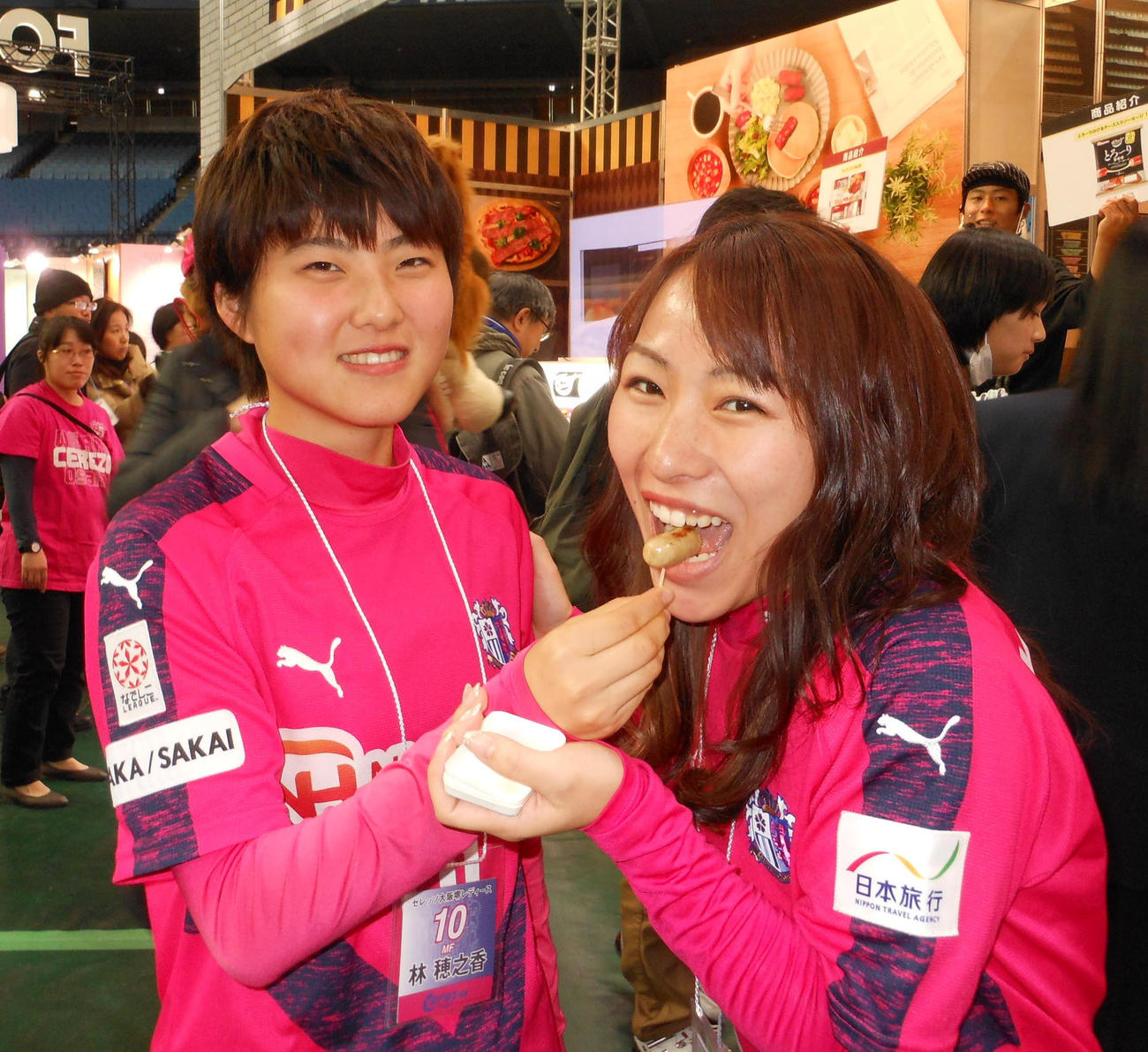 C大阪堺のMF林穂之香（左）は試食会で同僚のMF古沢留衣にウインナーを食べさせる