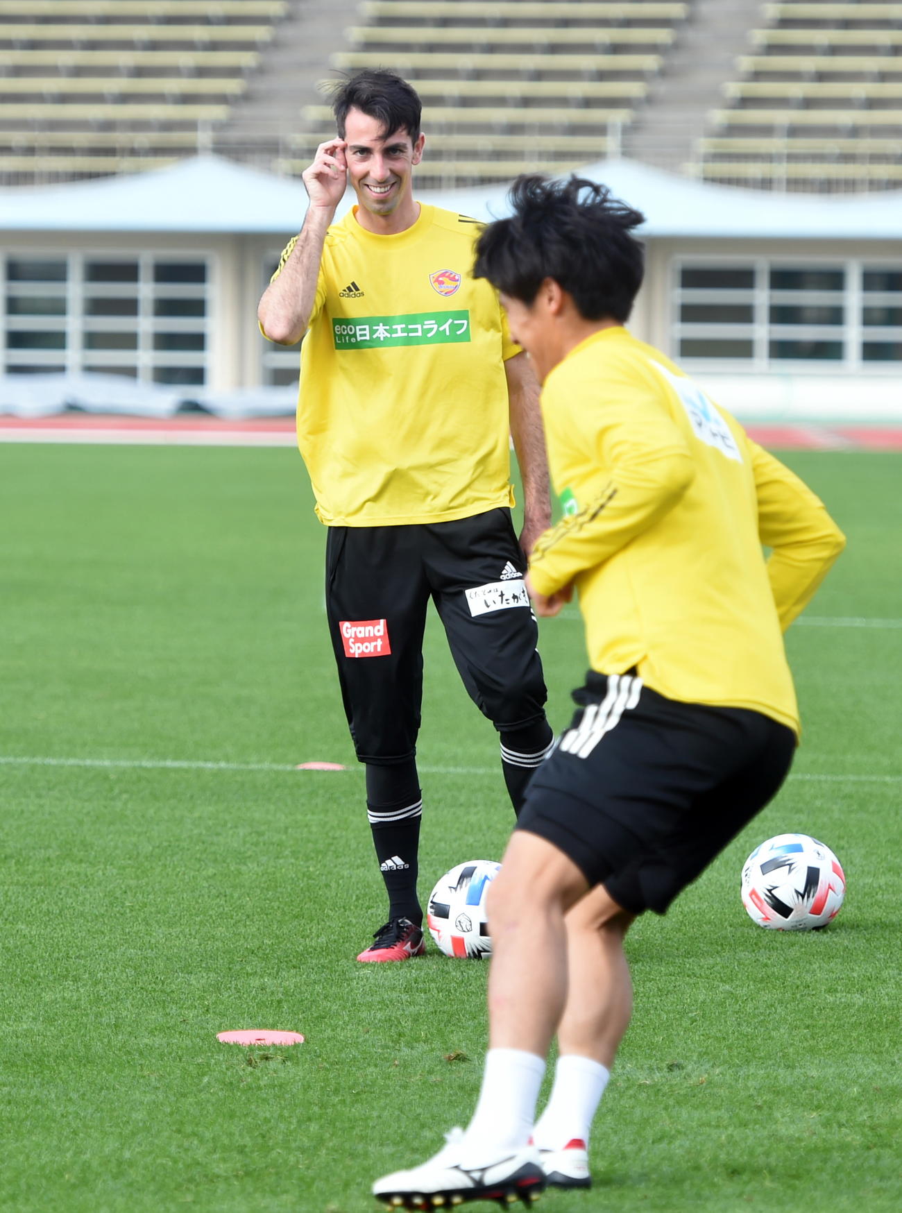 笑顔でフットワーク練習を見守る仙台MFクエンカ（奥）（撮影・山田愛斗）