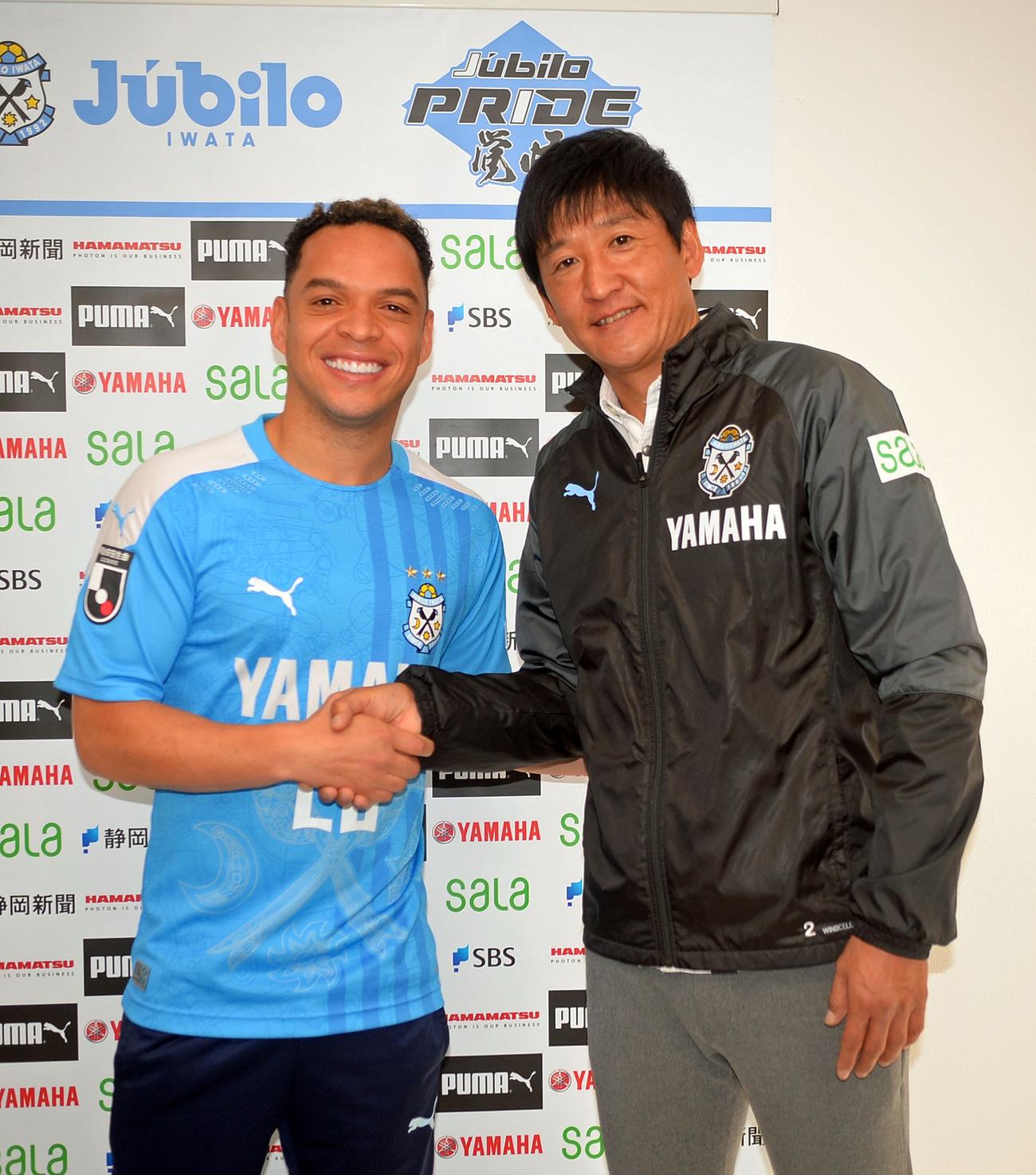 会見で握手する磐田FWルリーニャ（左）と鈴木強化部長