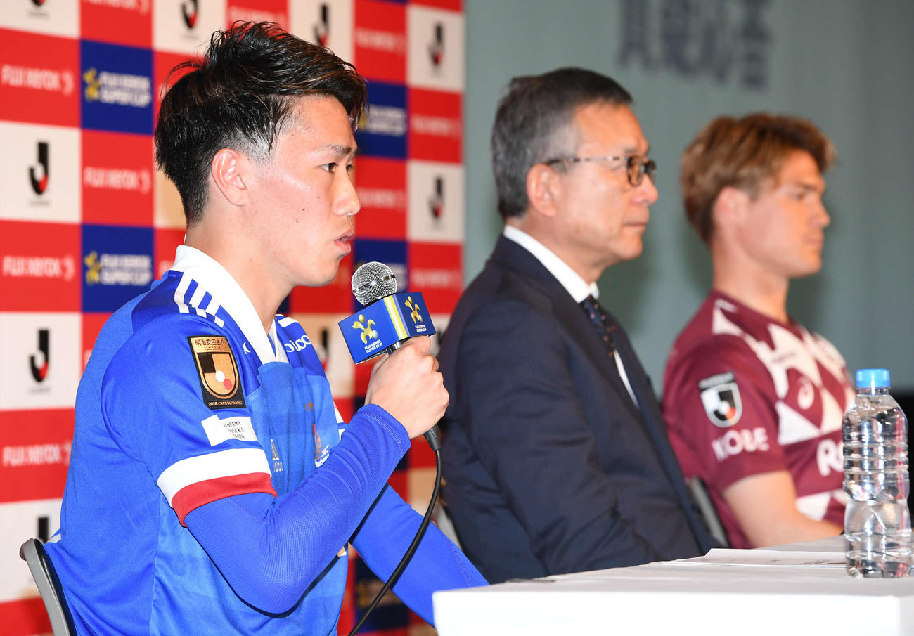 富士ゼロックス・スーパー杯の前日会見で横浜遠藤はリーグ優勝エンブレムのついたユニホームを着て意気込みを語る。中央は村井チェアマン、右は神戸酒井（撮影・山崎安昭）