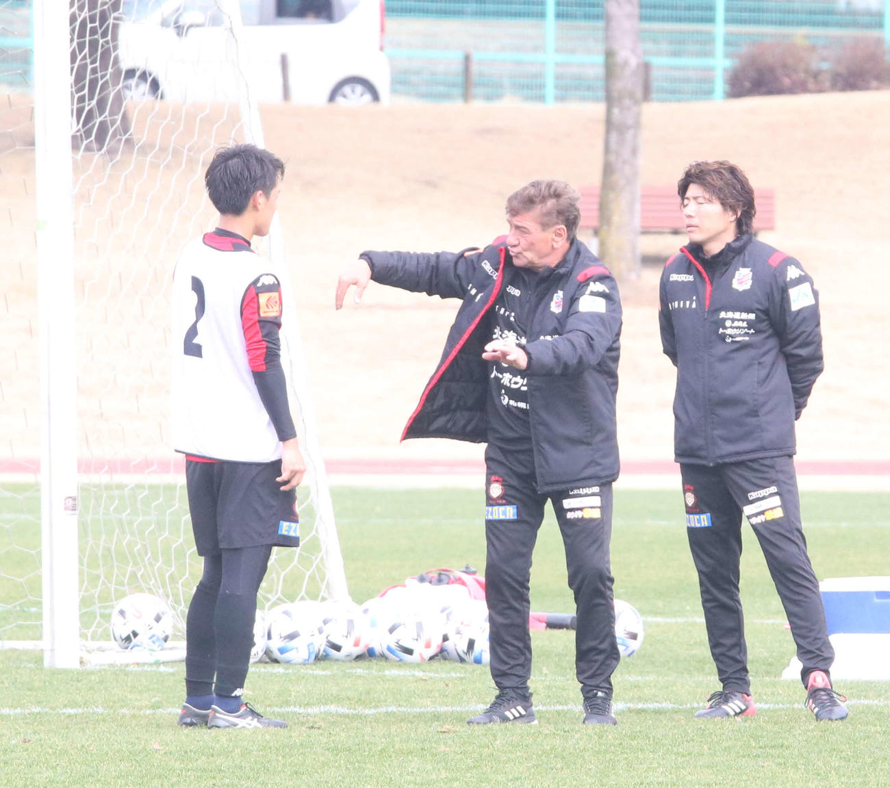 ルーキーの札幌MF高嶺（左）に身振り手振りを交えて指導するペトロビッチ監督（中央）。右は杉浦コーチ兼通訳（撮影・浅水友輝）