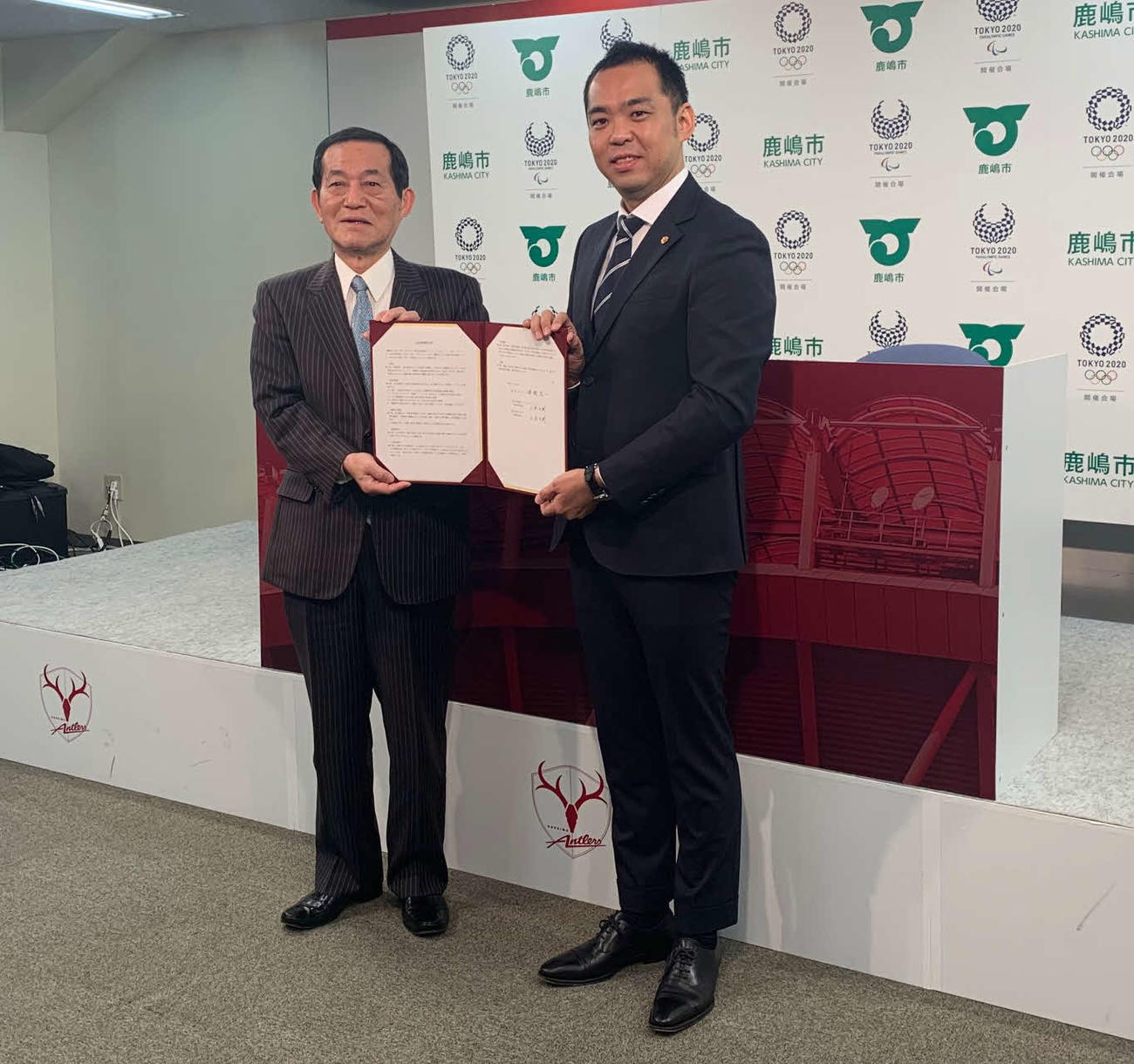 協定書を見せる鹿島アントラーズ小泉文明社長（右）と鹿嶋市の錦織孝一市長（撮影・杉山理紗）