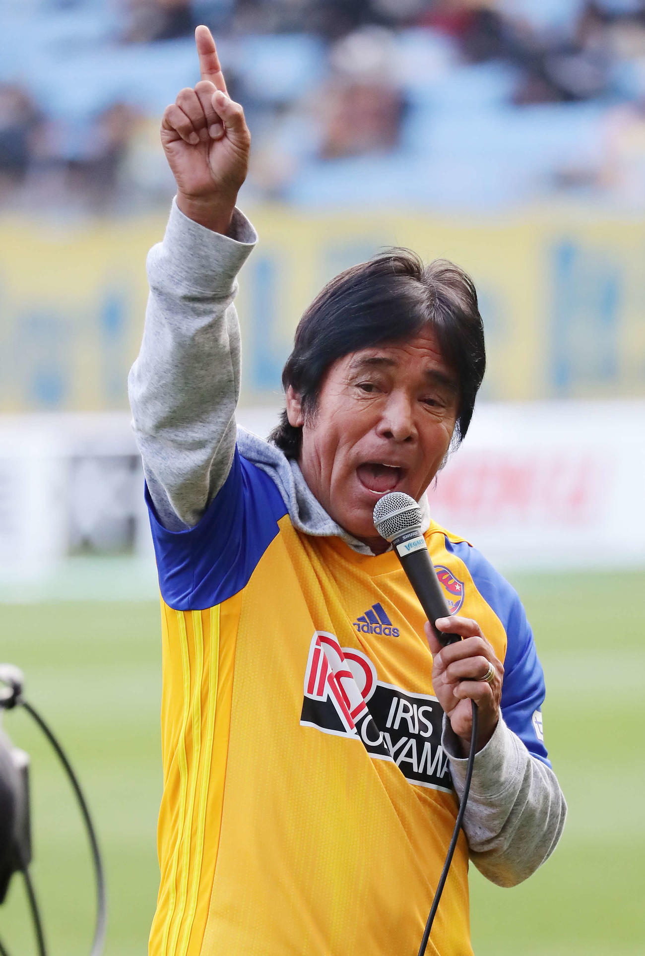 仙台対名古屋　ハーフタイムにピッチで熱唱するする松崎しげる（撮影・丹羽敏通）