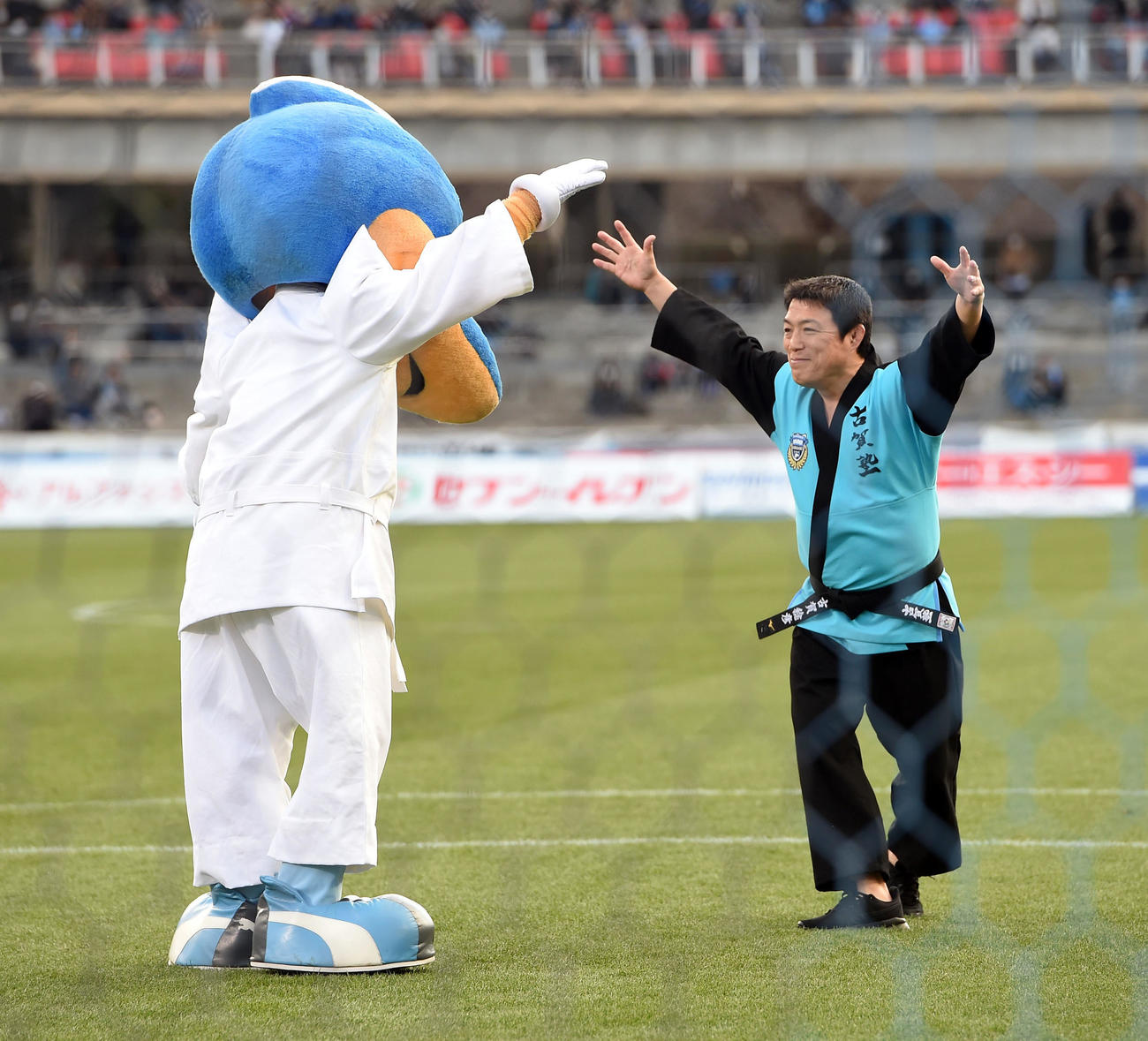 川崎F対鳥栖　始球式を前に川崎Fのマスコットのフロンタ君と対決する古賀稔彦氏（撮影・たえ見朱実）