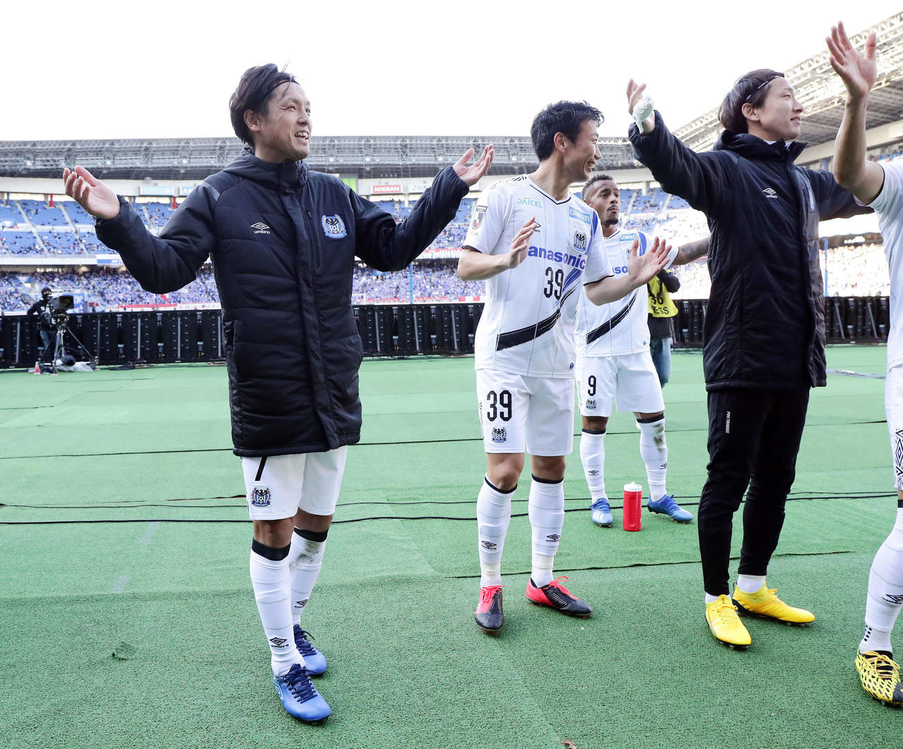 横浜対G大阪　2－1で開幕戦勝利を決め、サポーターの前で笑顔で手を広げるG大阪MF遠藤（左）（撮影・浅見桂子）