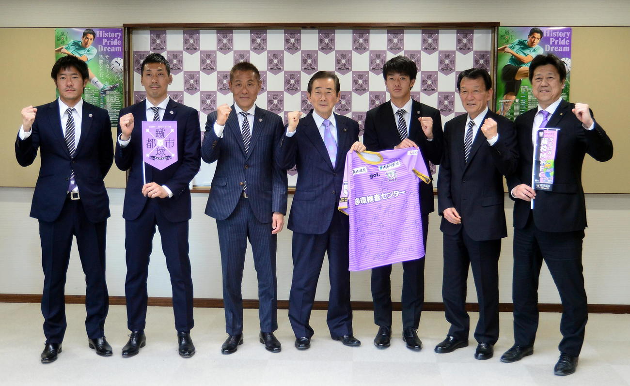 ガッツポーズで記念撮影に納まる北村市長（中央）と鎌田代表（右から2人目）らJ3藤枝の関係者