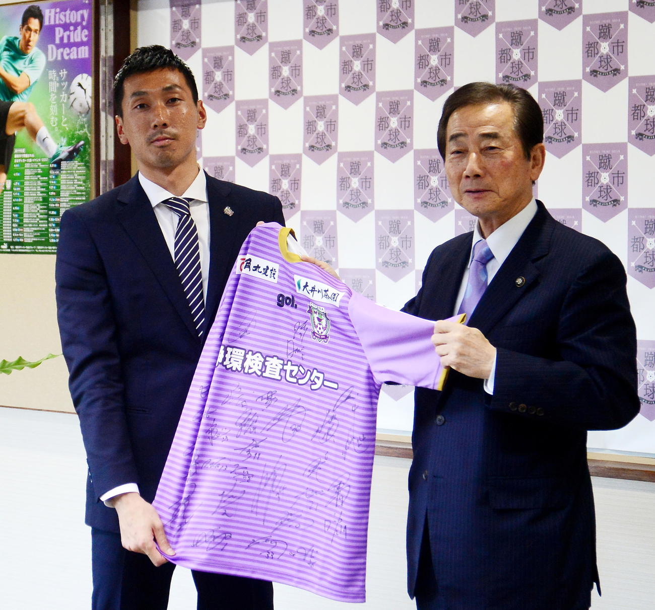 北村市長（右）に選手のサイン入りユニホームを贈呈する藤枝GK杉本