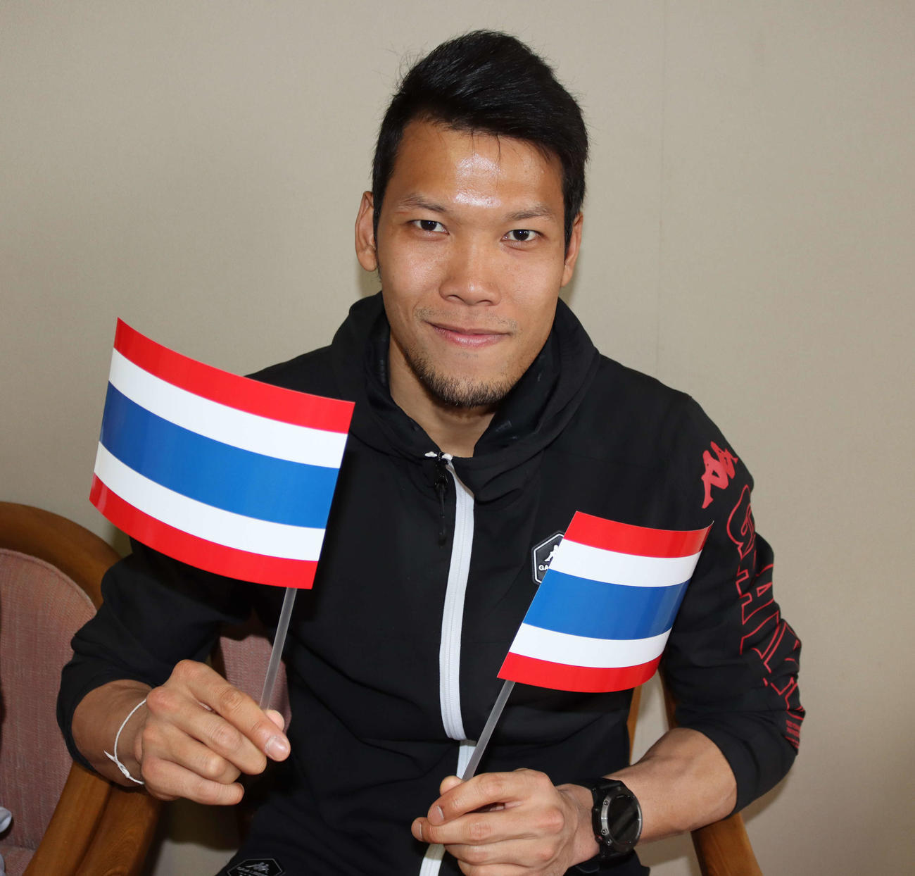 タイ国旗を手に笑顔の札幌GKカウィン（撮影・保坂果那）