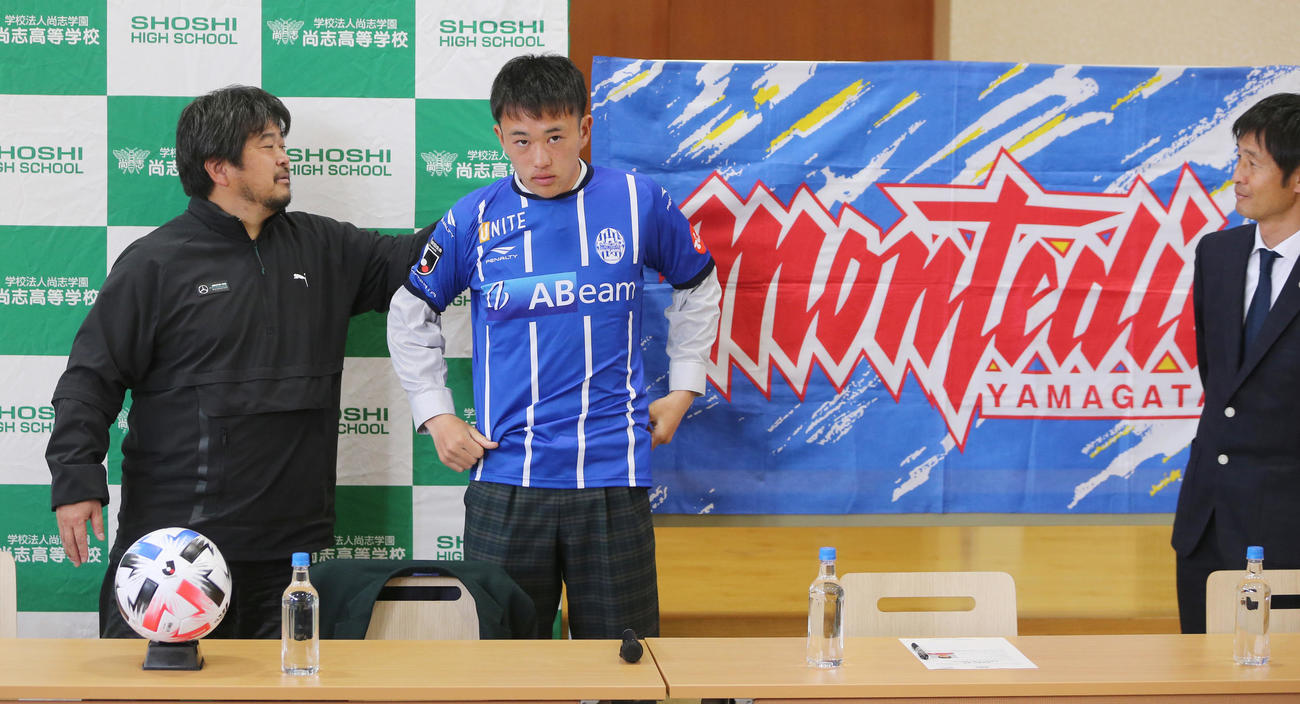 J2山形への入団内定会見を行った尚志FW阿部（中央）は、ユニホームを初めて着用し緊張の表情。左はえり元を直す仲村監督、右は山形高山強化本部長（撮影・野上伸悟）