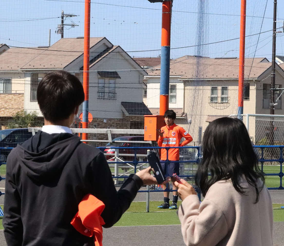 大宮では感染予防のため、選手と報道陣が約20メートル離れ、携帯電話のスピーカーフォンを通して取材対応する形式が取られ、大宮MF奥抜（後方）は手前の報道陣とスピーカーフォンを通して会話をした