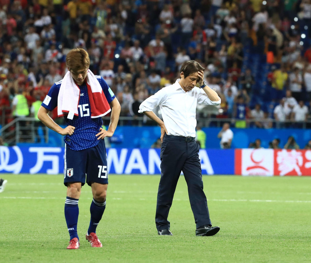 18年7月2日　日本対ベルギー　試合後、厳しい表情でサポーターにあいさつへ向かう西野監督（右）。左はFW大迫