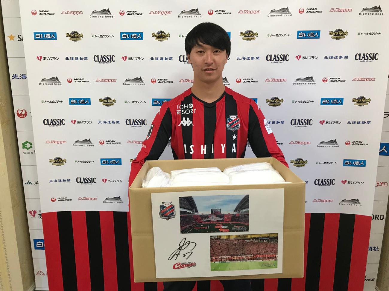 不織布マスク1万枚を医療機関に寄贈する札幌選手会の荒野会長（クラブ提供）