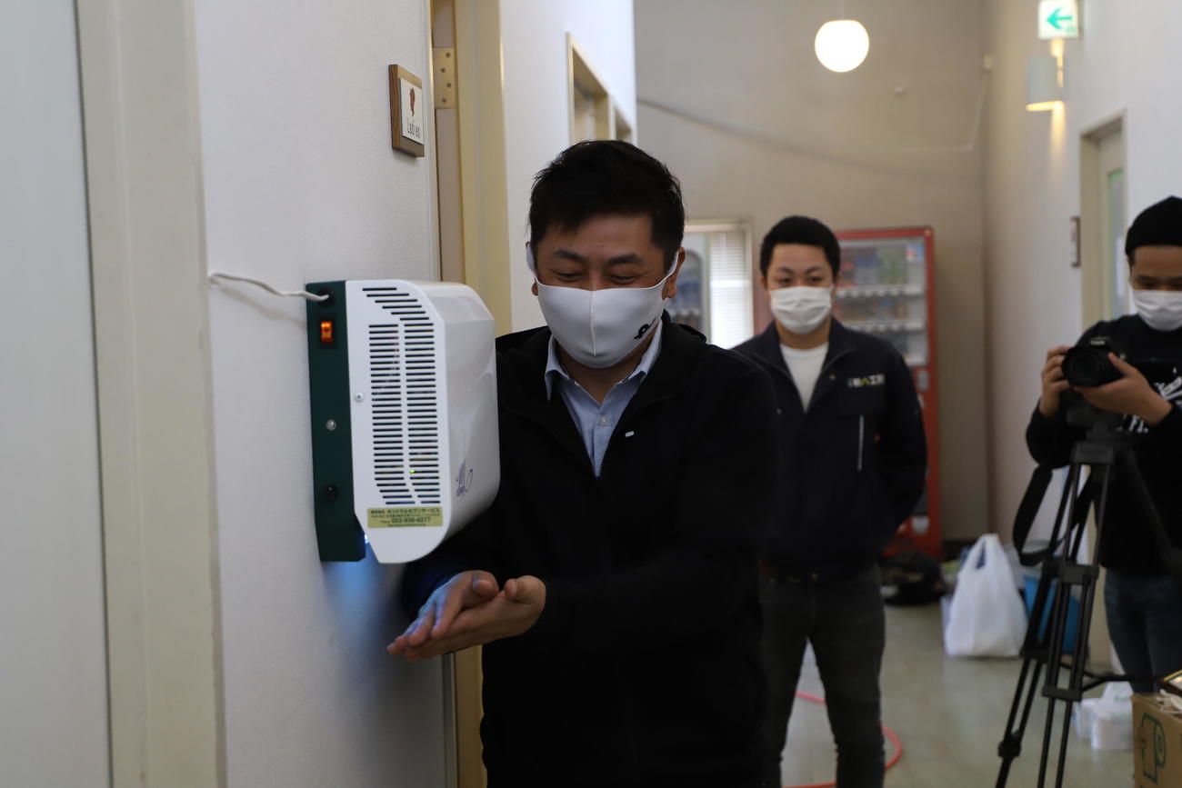 クラブハウスに設置された殺菌装置を試す札幌三上GM（クラブ提供）