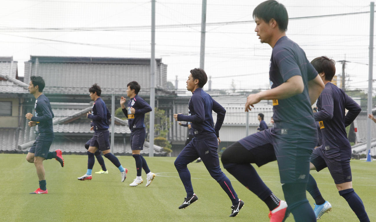 練習を再開し、距離を取りウオーミングアップする鳥栖の選手たち（撮影・菊川光一）