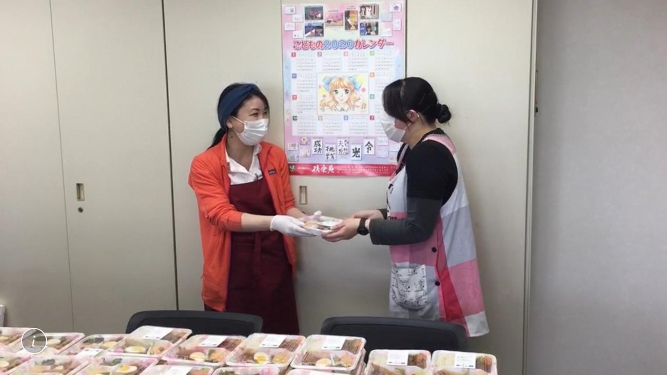 HokkaidoDreamから提供された弁当を受け取る札幌市内の児童養護施設職員（右）（HokkaidoDream提供）