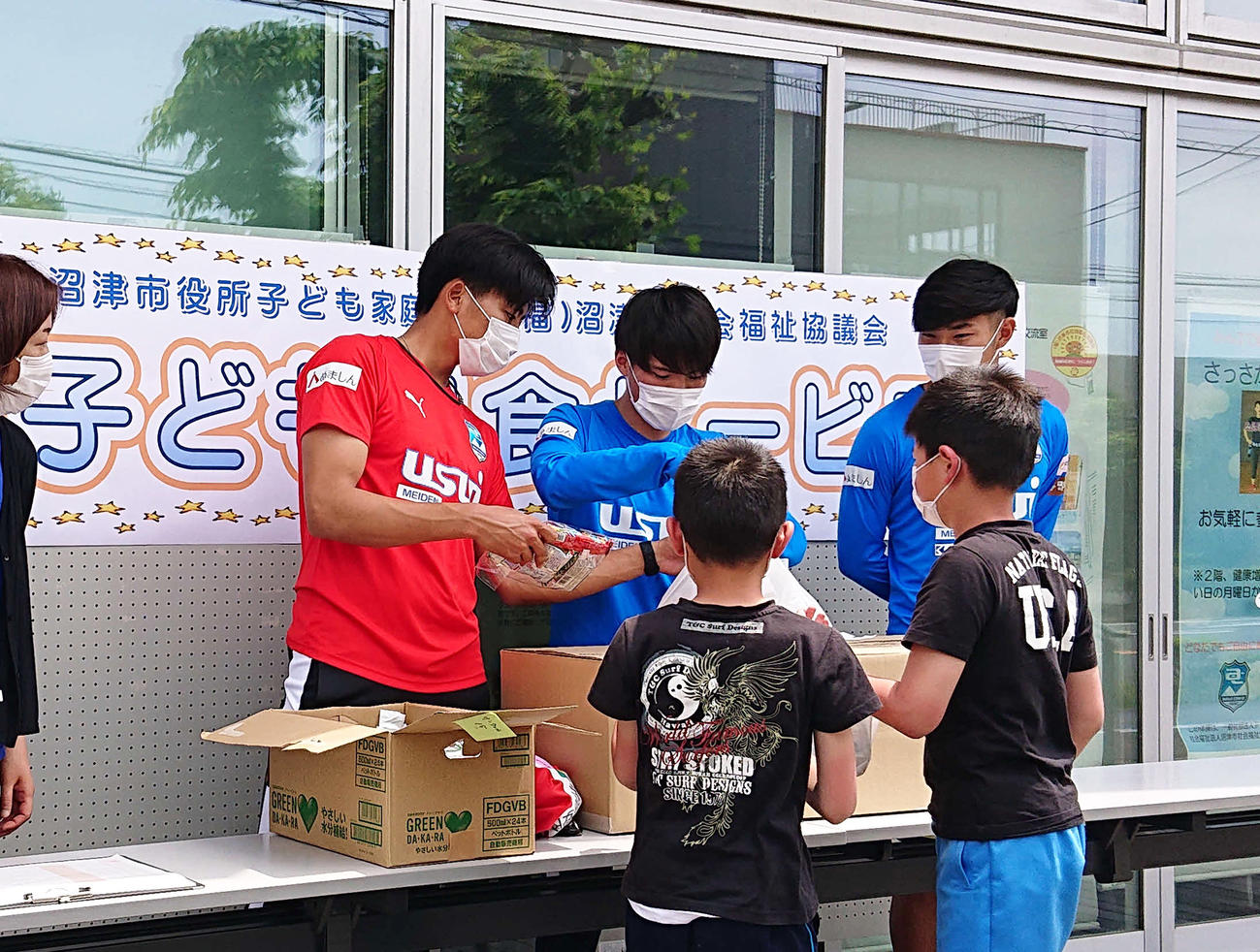 子どもたちへ昼食を配布する、左から沼津GK長沢、MF佐藤、FW渡辺（撮影・古地真隆）