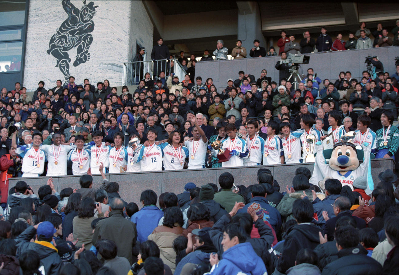 1999年1月1日、第78回天皇杯で優勝し、表彰式で笑顔を見せるDF前田浩二（13）、MF山口素弘（左から4人目）、FW吉田孝行（左から5人目）、MF波戸康弘（12）、MF三浦淳宏（6）、GK楢崎正剛ら横浜Fイレブン