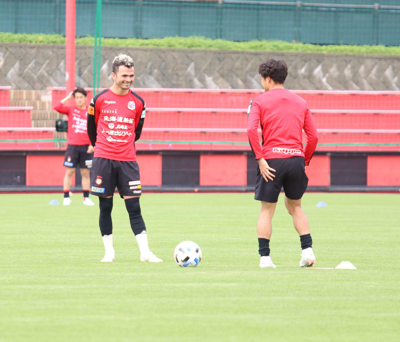 9日の練習中、札幌MFルーカス（左）はMF駒井と笑顔で会話する（撮影・保坂果那）