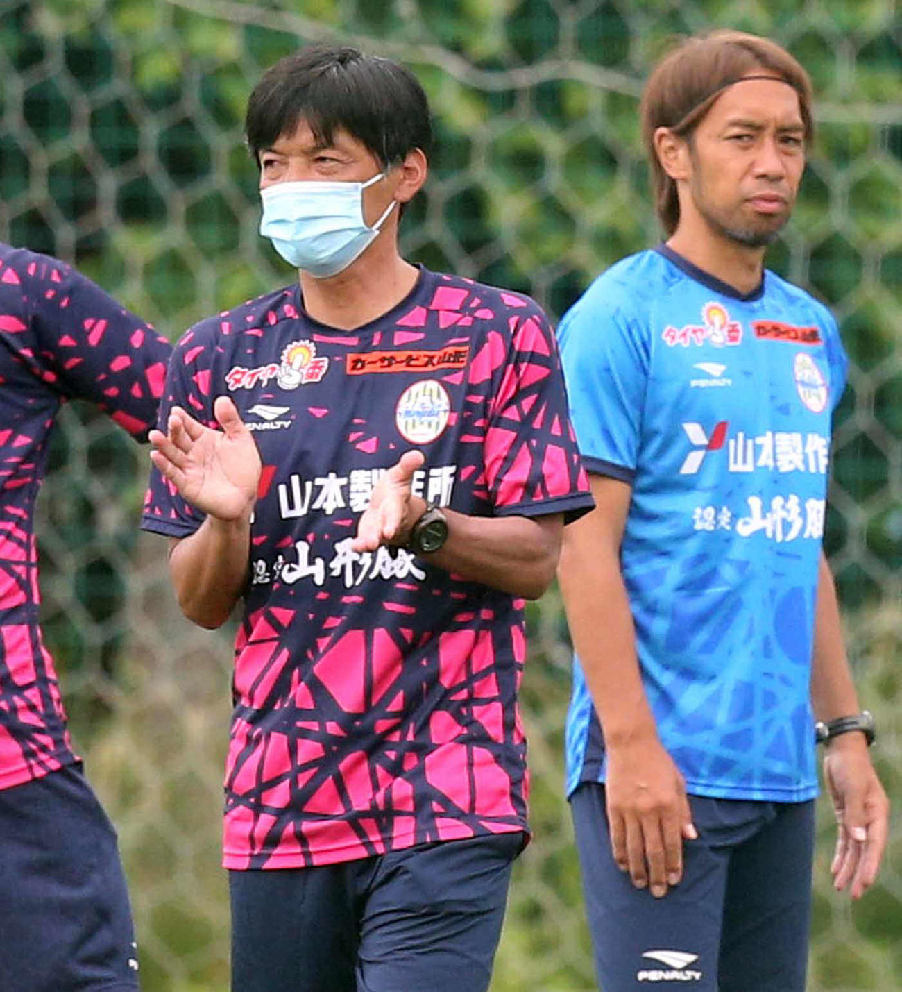 マスクを着用し練習を行う石丸監督、右は本田