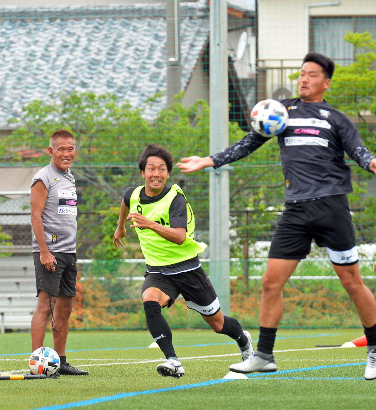 選手の動きを見つめる藤枝の石崎監督（左端）