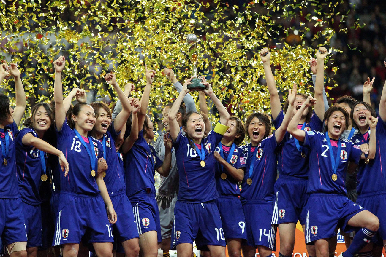 11年の女子W杯で世界一となり優勝杯を掲げる沢主将（中央）と歓喜のなでしこジャパンイレブン（11年7月17日）