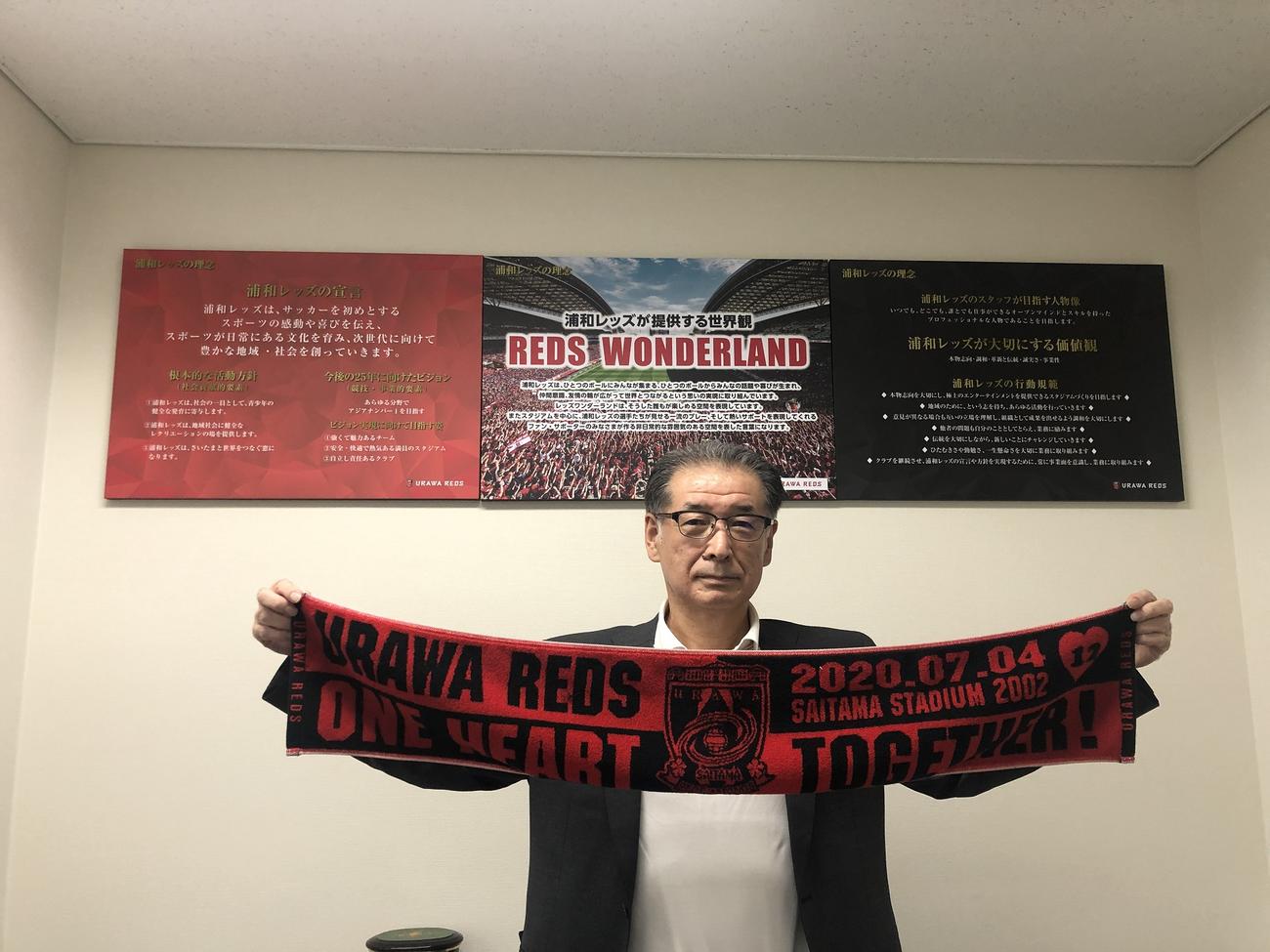 7月4日の今季再開初戦に埼玉スタジアムの客席に掲出されるタオルマフラーを持つ立花社長（浦和レッズ提供）
